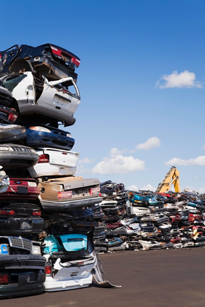 Large stacks of scrap cars in a junkyard facility.
