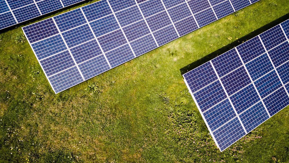 Aerial view of solar panels in a grassy field.