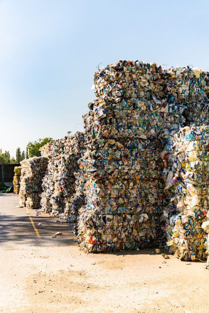 Large stacks of compressed recycling bales in an outdoor facility.