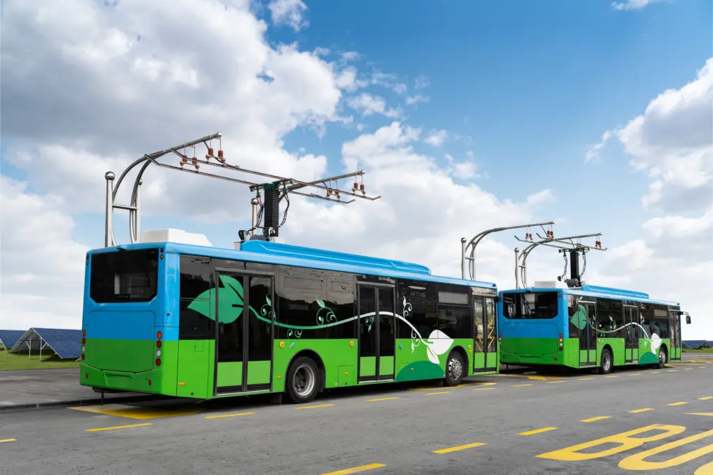 Two electric buses charging at a station.