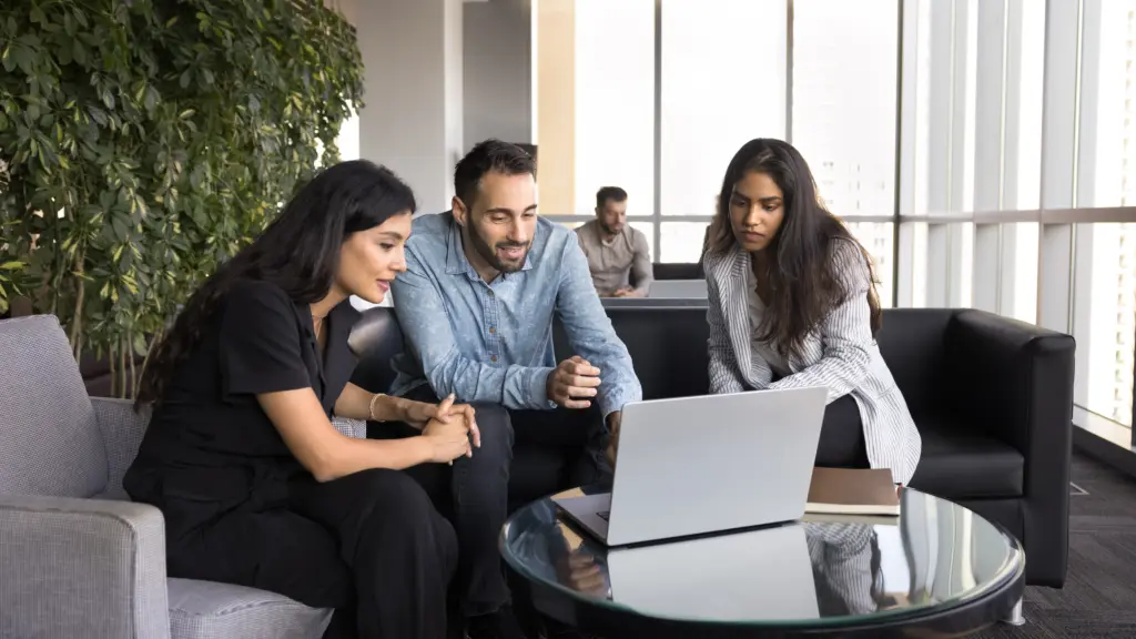 Colleagues collaborating on a laptop.