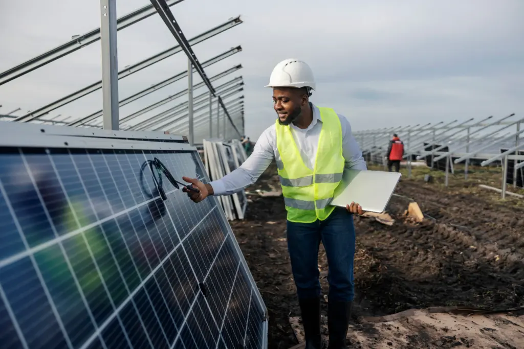 Engineer inspecting solar panel at solar farm.