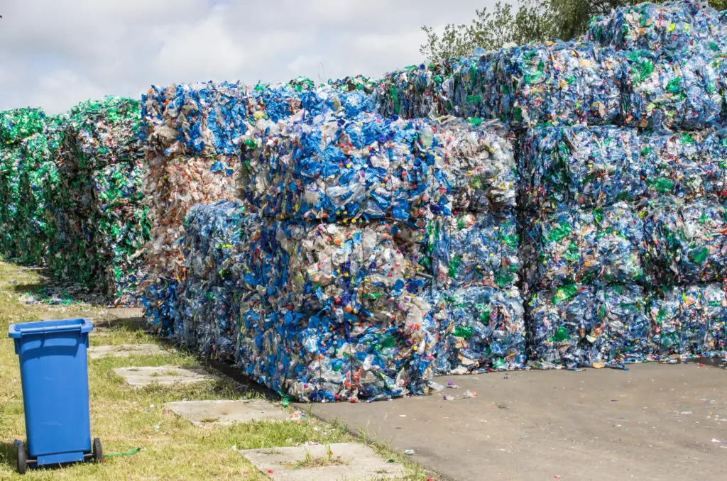 Bales of recycled plastic bottles at a collection site.